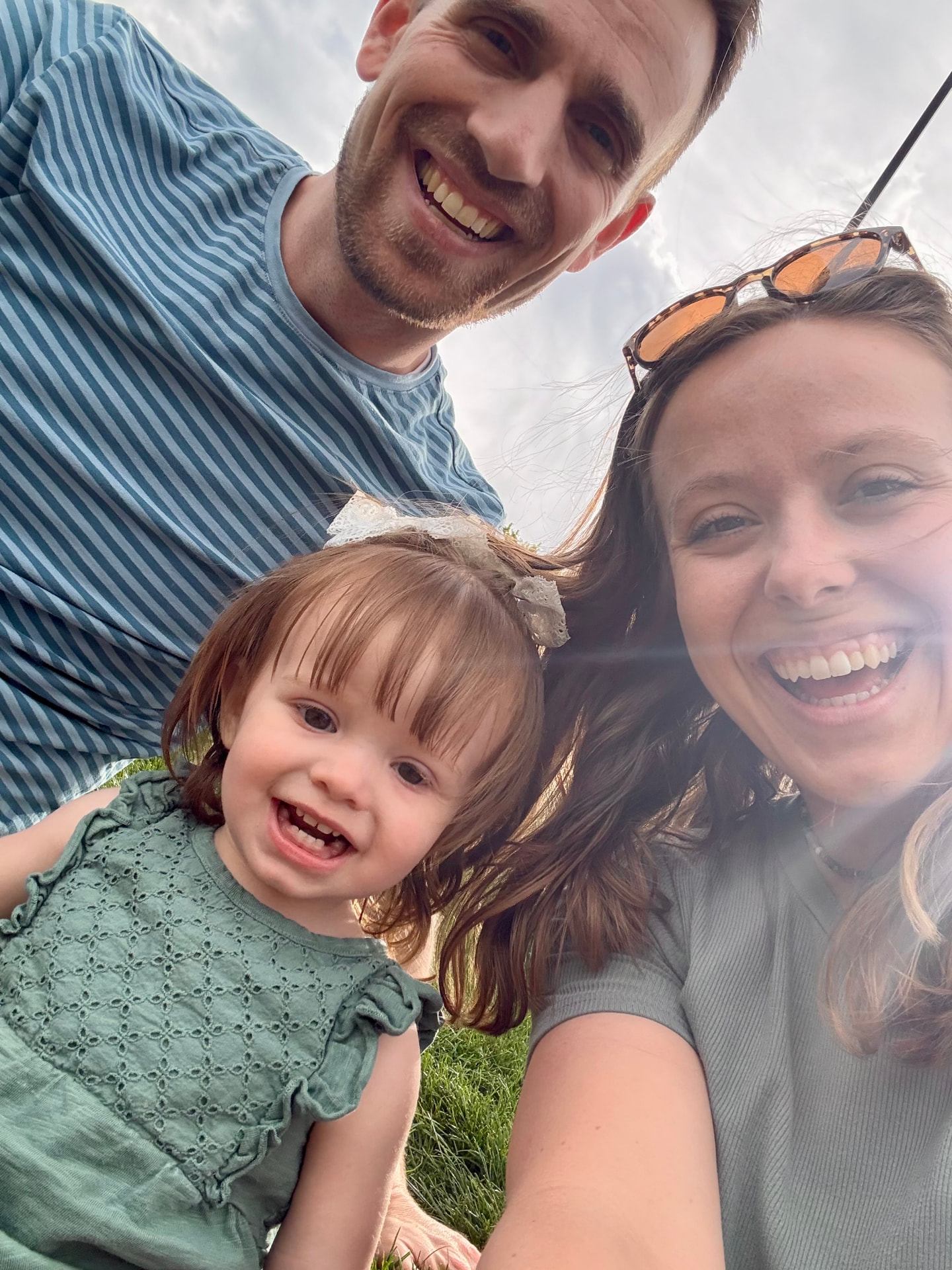 Spencer Steele with his wife and daughter outdoors on the grass